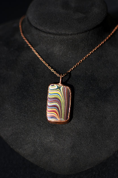 Necklace with a colorful Fordite pendant on a black background