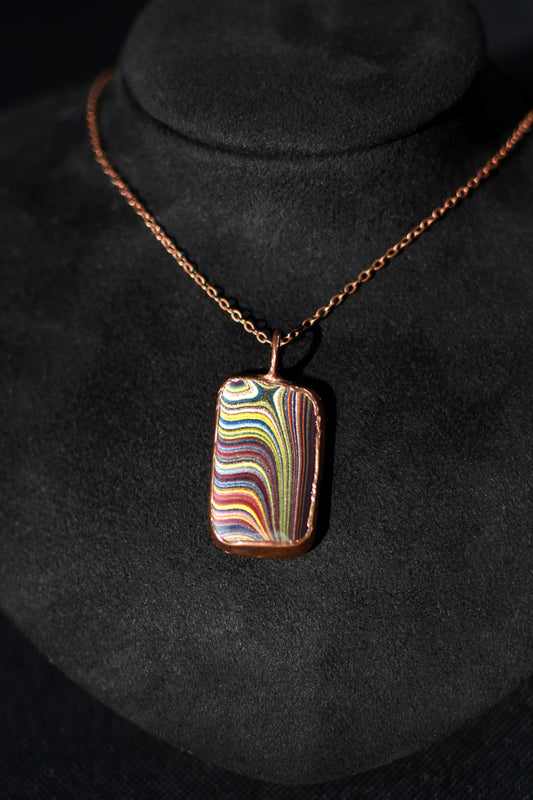 Necklace with a colorful Fordite pendant on a black background