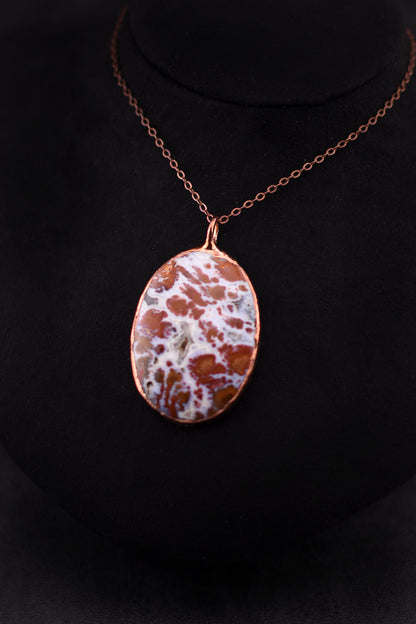 Wingate Pass Plume Agate pendant necklace electroformed in copper on a black background. 