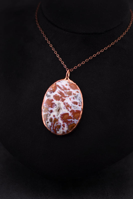 Wingate Pass Plume Agate pendant necklace electroformed in copper on a black background. 